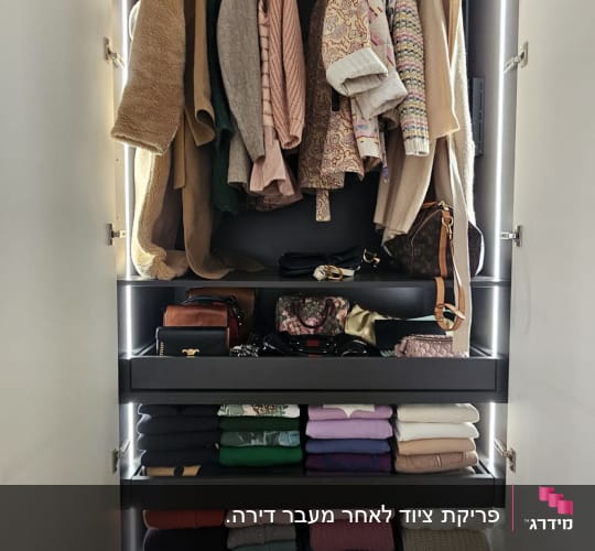 ארון בגדים מסודר עם בגדים תלויים ומקופלים